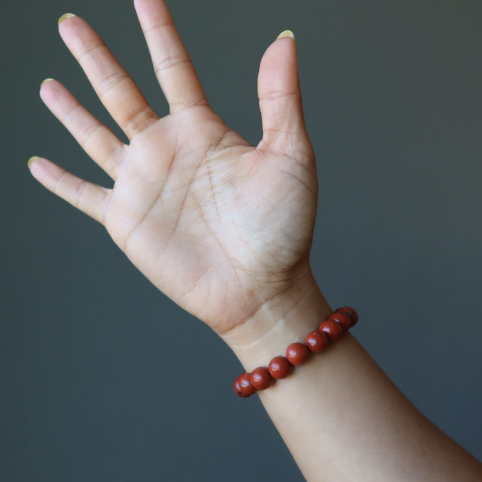 hand wearing red jasper bracelet