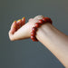 hand wearing red jasper bracelet