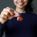 hand holding red jasper bear pendant at chest