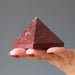 hand holding red jasper pyramid