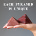 hand holding two red jasper pyramids
