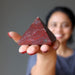 sheila of satin crystals holding out a red jasper pyramid