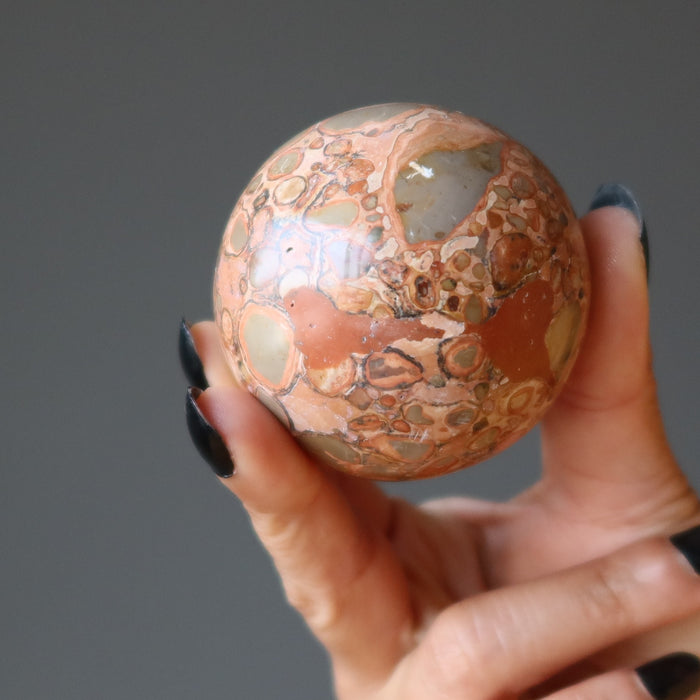 hand holding safari jasper sphere