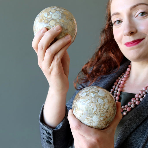 female model holding two snake jasper spheres