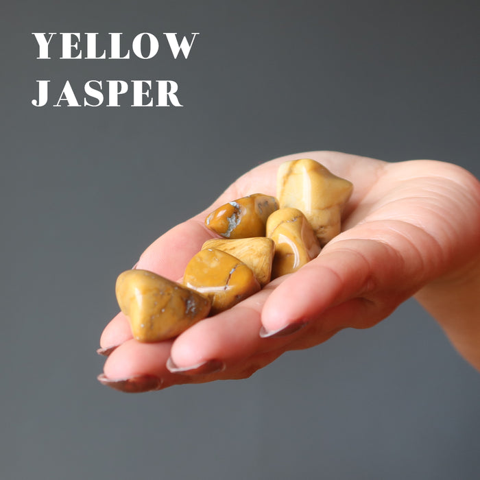hand holding yellow jasper tumbled stones