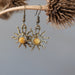 yellow jasper sun earrings hanging on a branch