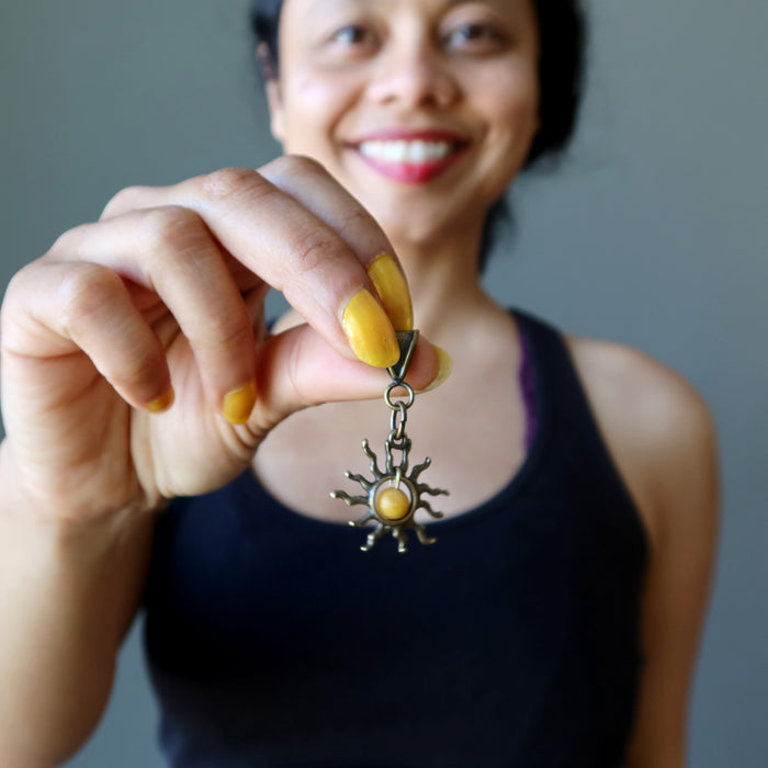 sheila of satin crystals holding a yellow jasper sun pendant