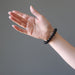 woman's hand wearing black jet stone round beaded stretch bracelet