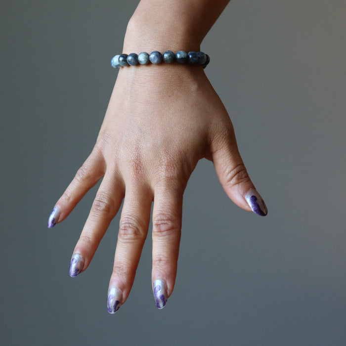 female hand wearing blue kyanite beaded stretch bracelet