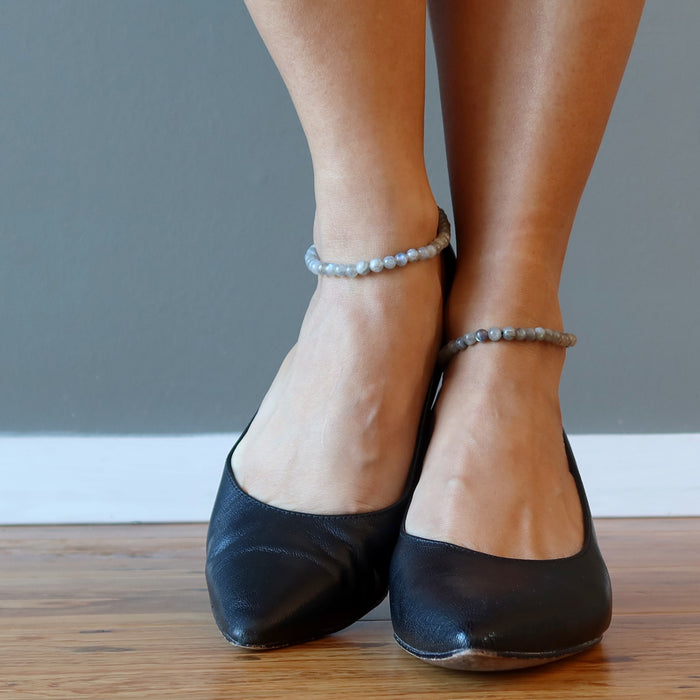 pair of high heeled feet wearing labradorite anklets