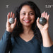 woman holding two labradorite spheres in different sizes