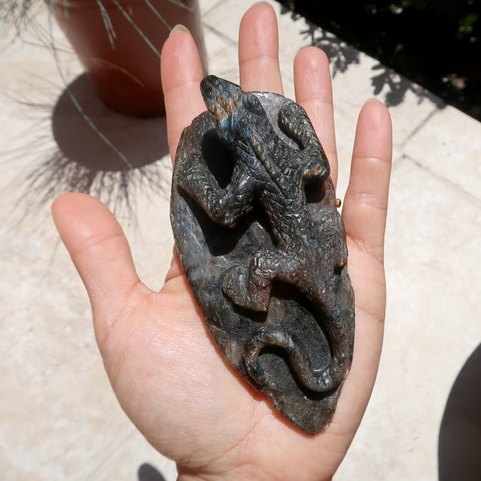 hand holding up a labradorite lizard carving