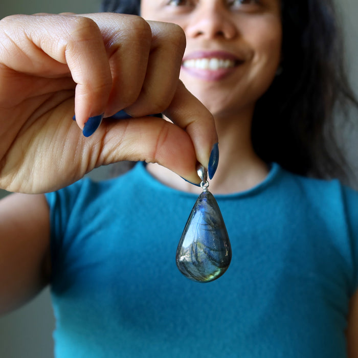 sheila of satin crystals holding a labradorite teardrop pendant