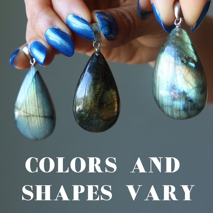 hand holding 3 labradorite teardrop pendants to see colors and shapes vary
