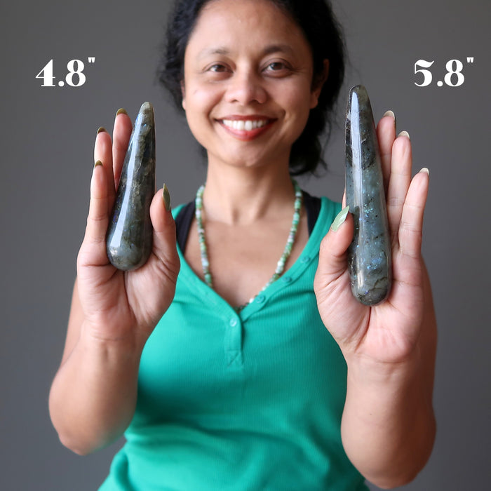sheila of satin crystals holding two labradorite massage wands to show size difference between 4.8" and 5.8"