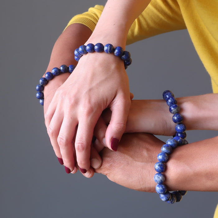 man and women's four hands intertwined wearing lapis lazuli stretch bracelets