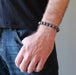 man's hand in his jean pockets wearing a lapis lazuli and pyrite round beaded stretch bracelet