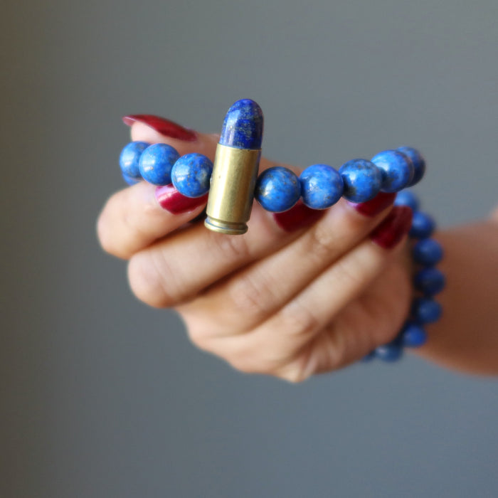 hand holding a lapis peace bullet stretch bracelet