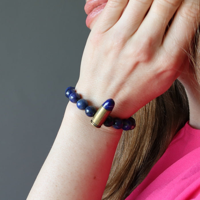 hand on face hand wearing a lapis peace bullet stretch bracelet