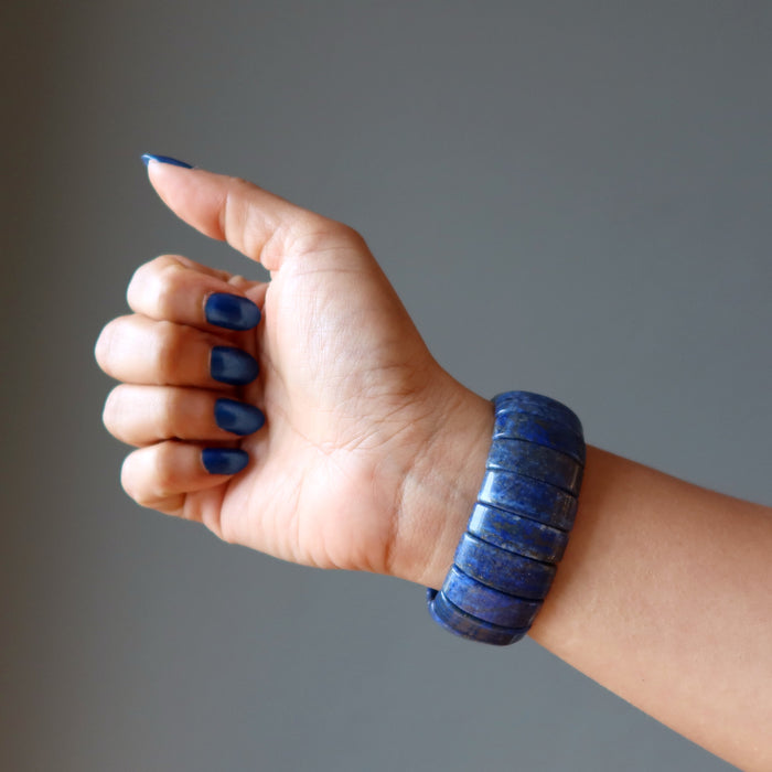 hand wearing a chunky lapis lazuli stretch cuff bracelet