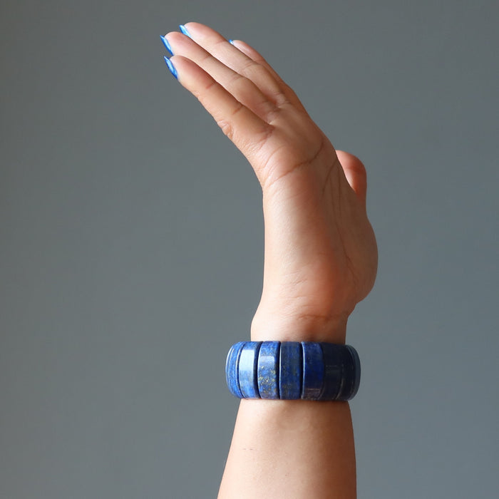 hand wearing a chunky lapis lazuli stretch cuff bracelet