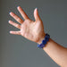 back of hand outstretched rounded rectangle lapis beaded stretch bracelet