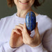 female holding lapis lazuli oval palm stone crystal