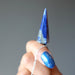 hand holding lapis lazuli crystal healing sterling silver pendulum