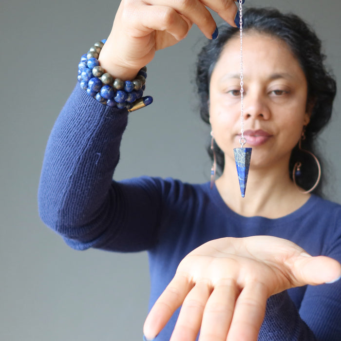 sheila of satin crystals holding a lapis lazuli sterling silver pendulum over her palm for dowsing