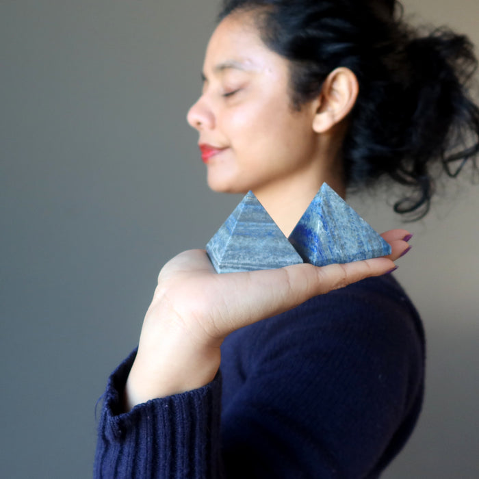 sheila of satin crystals holding two lapis pyramids