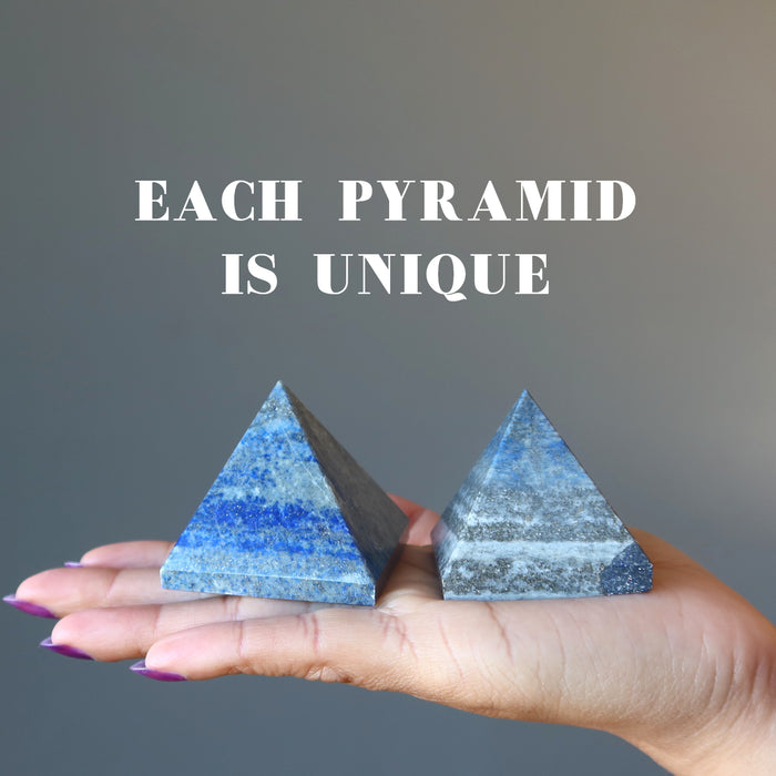 hand holding two lapis pyramids