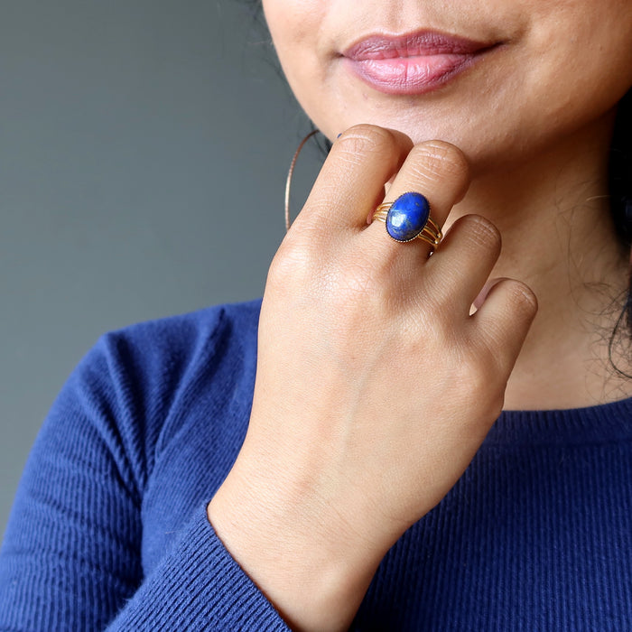hand on chin wearing lapis lazuli gemstone in gold tone adjustable ring