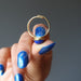 hand holding lapis lazuli gemstone in gold tone adjustable ring