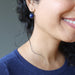 on ear wearing round lapis lazuli in antique bronze leverback earrings