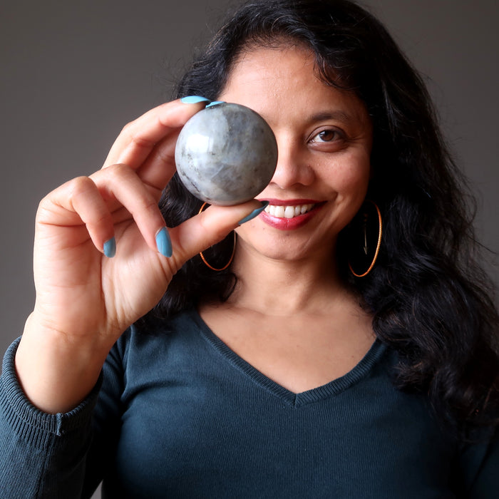 sheila of satin crystals holding up a labradorite sphere