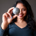 sheila of satin crystals holding up a labradorite sphere