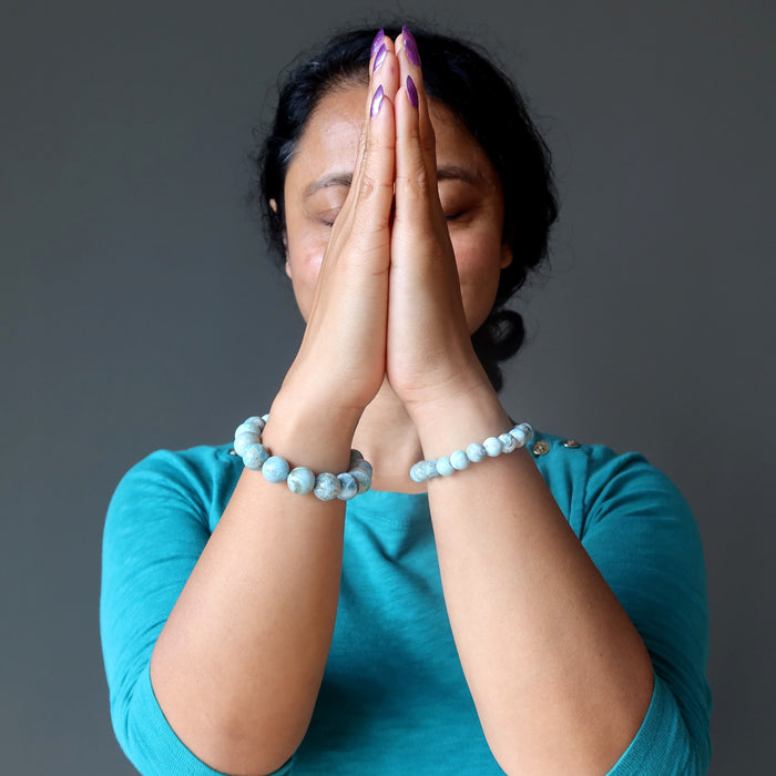 woman praying with larimar bracelet on wrist