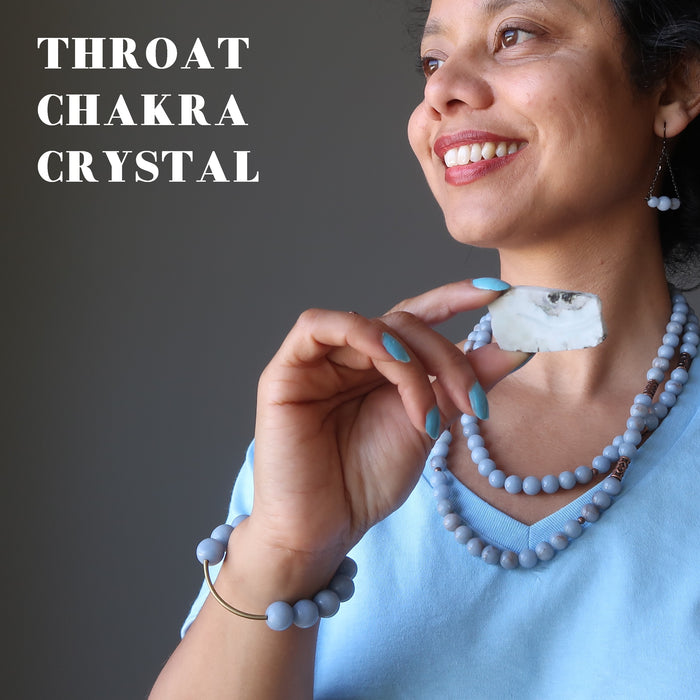 sheila of satin crystals holding a larimar slab at her throat chakra