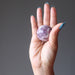 hand holding quartz lepidolite sphere