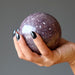 purple lepidolite sphere in hand