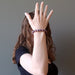A female model shows off a purple lepidolite healing crystal bracelet on her wrist