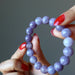 hands holding purple lepidolite bracelet
