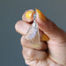 hand holding yellow libyan desert glass raw pendant