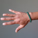 man's hand wearing green malachite bracelet