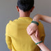 women's hands on man's back featuring 3 malachite bracelets
