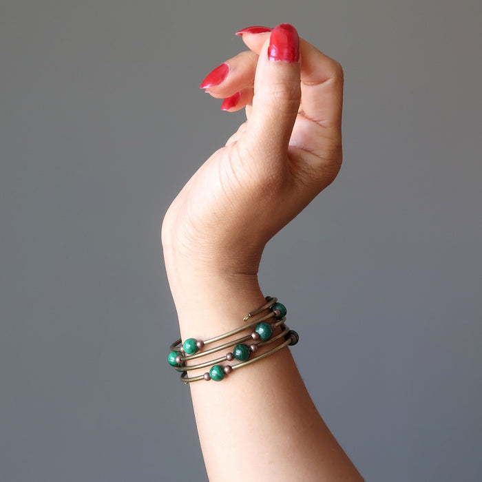 A woman's hand and arm showing off the Malachite vintage coil bracelet