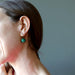 holly of satin crystals wearing malachite stones in antique leverback earrings