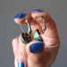 hands holding malachite bronze leverback earrings 