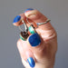 hands holding malachite bronze leverback earrings 