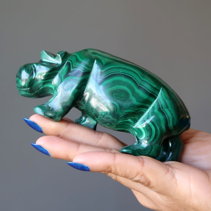 hand holding a malachite hippo figurine